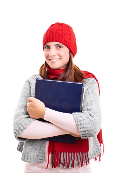 Leende elev i vinterkläder håller en bok — Stockfoto