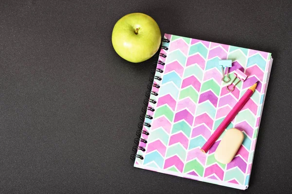 黑色背景的粉红色笔记本和苹果 — 图库照片