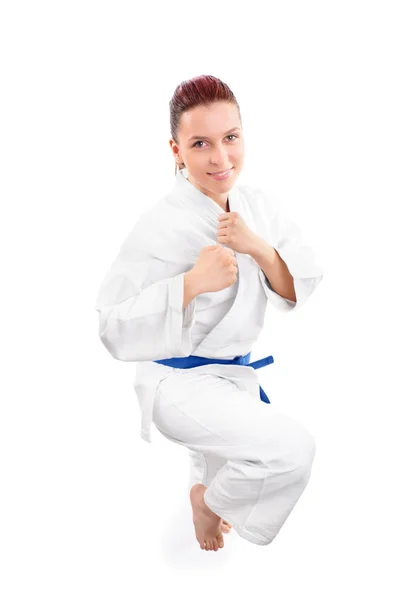 Улыбающийся боец в кимоно с поднятым коленом — стоковое фото