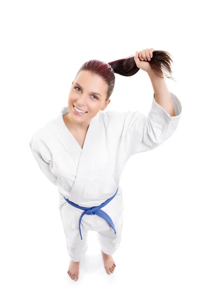 Sonriente chica de karate sosteniendo su cola de caballo — Foto de Stock