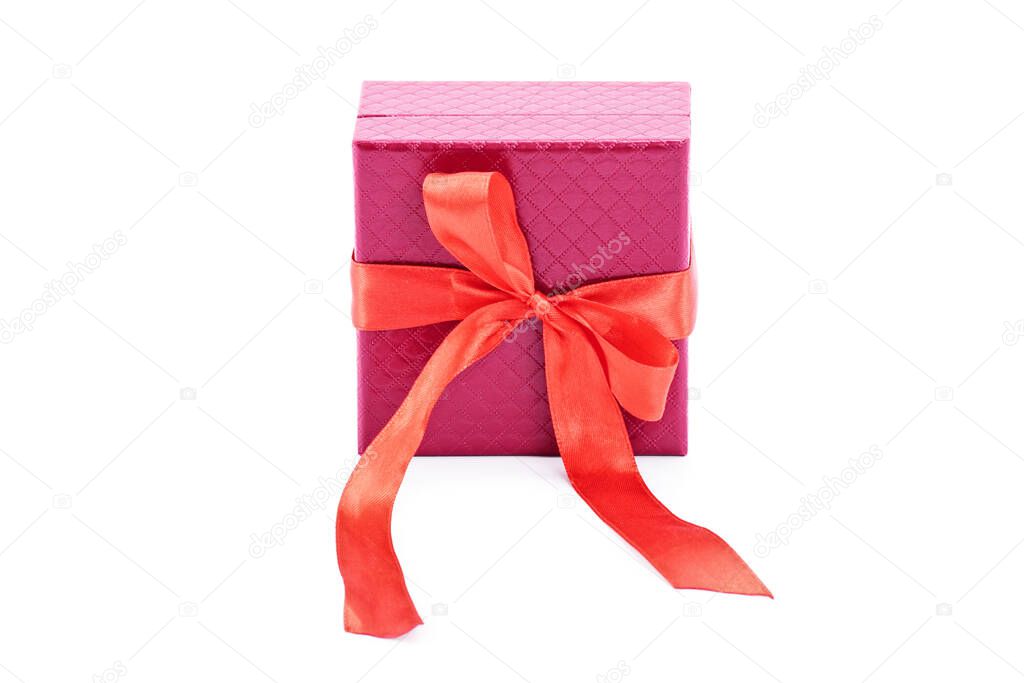 Close up of a red gift box and red bow ribbon, isolated on white background. Christmas, New Year, anniversary, birthday, Valentines Day concept.