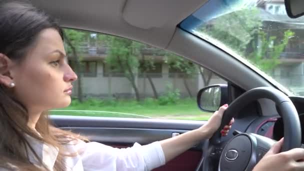 Den unga flickan bakom ratten i en bil — Stockvideo