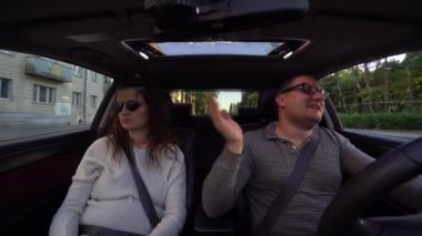 Çift gülüyor ve araba sürüş sarılma