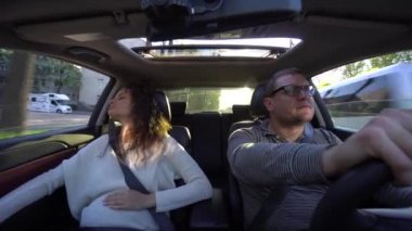 Çift gülüyor ve araba sürüş sarılma