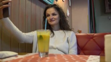 Güzel heyecan verici genç kadın selfiein kafe yapma.