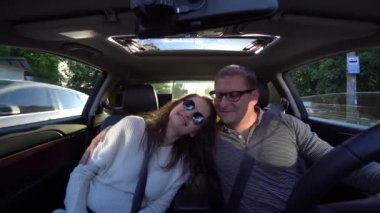 Çift gülüyor ve araba sürüş sarılma