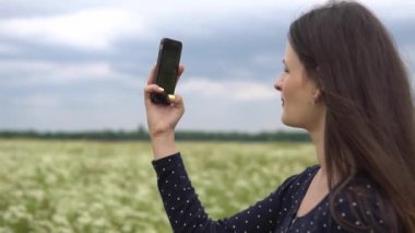 Güzel kız selfie, papatya çiçekleri dışında fotoğraf yapıyor.
