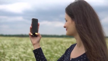 Güzel kız selfie, papatya çiçekleri dışında fotoğraf yapıyor.