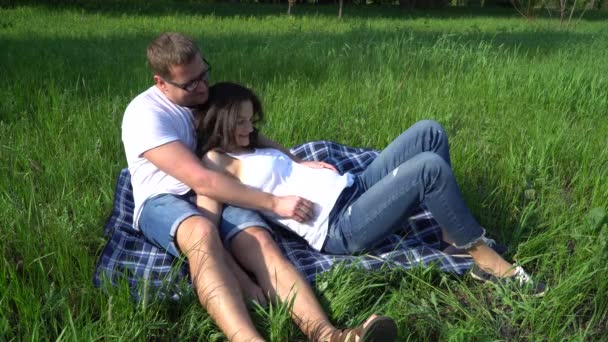 Młodej rodziny jest oczekiwania na dziecko. Mężczyzna całuje żonę w ciąży. — Wideo stockowe