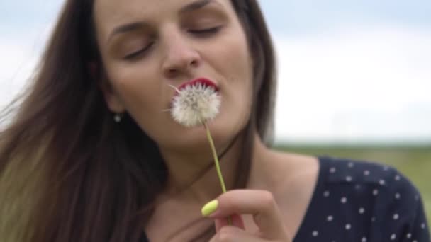 Den unge kvinde blæser mælkebøtte i parken i slowmotion . – Stock-video