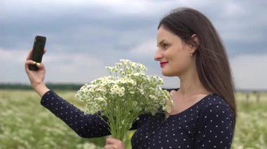 Güzel kız selfie, papatya çiçekleri dışında fotoğraf yapıyor.