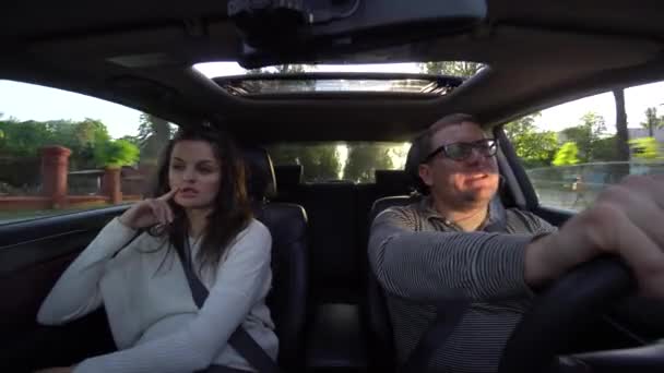 Paar lacht und kuschelt beim Autofahren — Stockvideo
