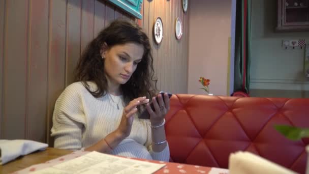 Woman using app on smartphone in cafe — Stock Video