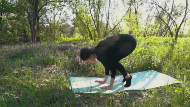 Young pregnant woman doing yoga outside. — Stock Video