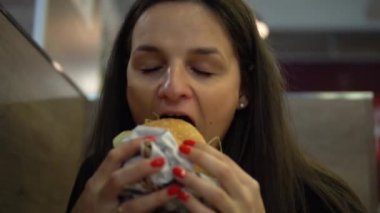 Aç kız hamburger yeme. Çizburger fast food Restoran, ısırma kadın