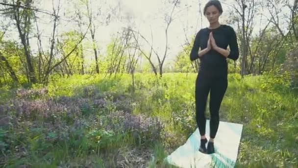 Joven embarazada haciendo yoga fuera . — Vídeo de stock