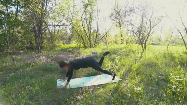 Молода вагітна жінка робить йогу зовні . — стокове відео