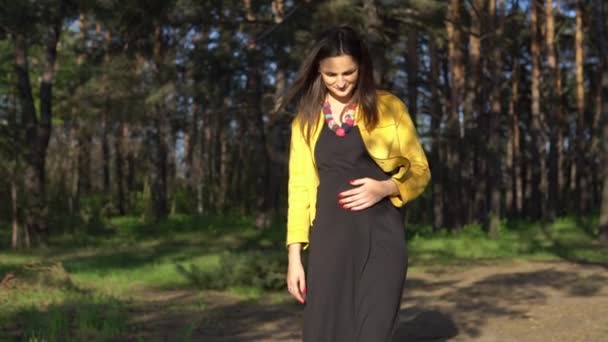 Женщина трогает ее беременный живот — стоковое видео