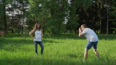 Yakışıklı adam parkta genç mutlu hamile kadın kamera ile fotoğraf çeker
