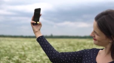 Güzel kız selfie, papatya çiçekleri dışında fotoğraf yapıyor.