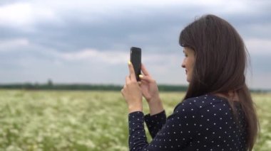 Güzel kız selfie, papatya çiçekleri dışında fotoğraf yapıyor.