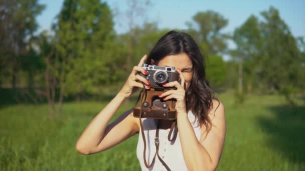 Genç kadın fotoğrafçı fotoğraf ve kamera açık havada ile fotoğraf çekimi. — Stok video