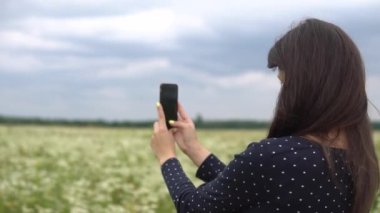 Güzel kız selfie, papatya çiçekleri dışında fotoğraf yapıyor.