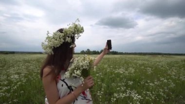 Selfie, papatya çiçekleri dışında fotoğraf yapıyor güzel hamile kız.