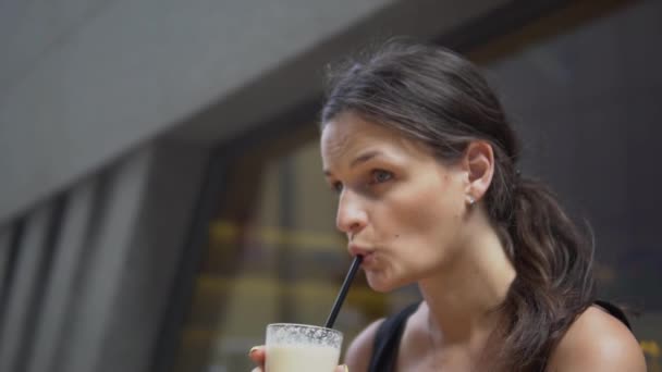 若い美しい女性がバーでミルクセーキを飲む. — ストック動画