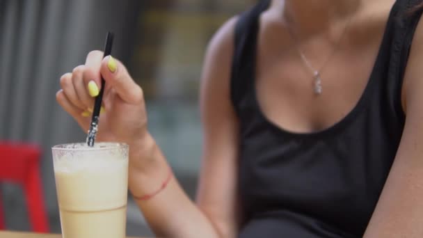 La jeune belle femme boit un milk-shake au bar . — Video