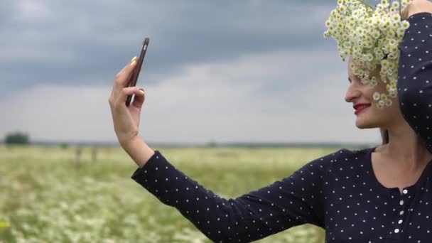 Hermosa chica haciendo selfie, foto con flores de manzanilla afuera . — Vídeo de stock