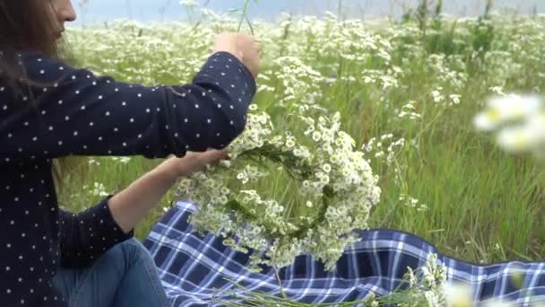 Gelukkig zwangere vrouw kamille krans maken. — Stockvideo