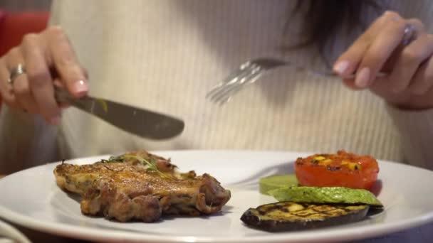 Vrouw genieten van de smaak van gegrilde steak in restaurant — Stockvideo