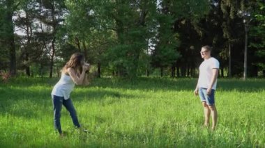 Hamile kadın fotoğrafçı açık havada fotoğraf çeker.