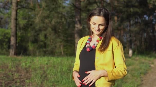 Жінка торкається вагітного живота — стокове відео