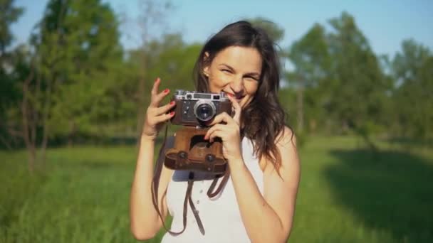 Genç kadın fotoğrafçı fotoğraf ve kamera açık havada ile fotoğraf çekimi. — Stok video