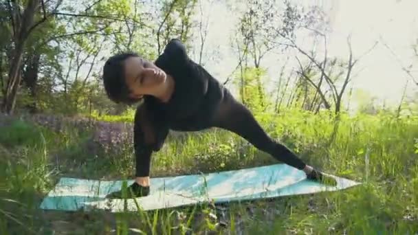 Joven embarazada haciendo yoga fuera . — Vídeo de stock