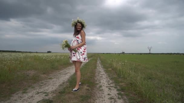 Gravid kvinna med bukett på kamomill blommor. — Stockvideo