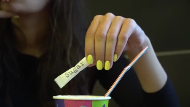 Dívka vyvolává cukru v šálku kávy. Ženské ruce šálek americano. — Stock video