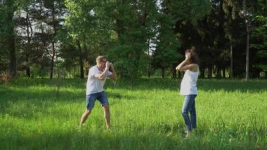 Yakışıklı adam parkta genç mutlu hamile kadın kamera ile fotoğraf çeker