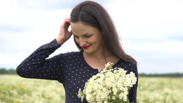 Beautiful women smelling white camomiles in summertime outdoors. — Stock Video