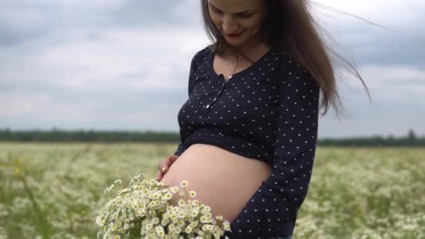 Gravid kvinna med bukett på kamomill blommor. — Stockvideo