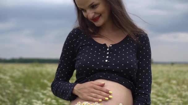 Gravid kvinna med bukett på kamomill blommor. — Stockvideo