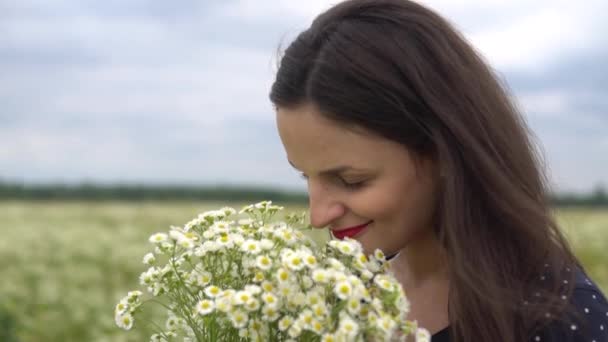 Schöne Frauen, die weiße Kamillen im Sommer im Freien riechen. — Stockvideo