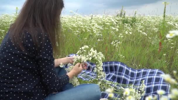 Gelukkig zwangere vrouw kamille krans maken. — Stockvideo