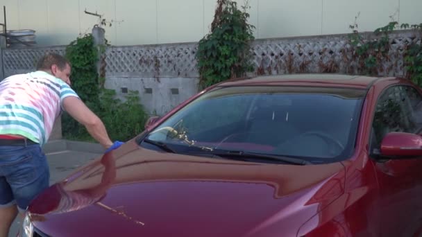 Young caucasian man washing his car on the car wash self-service. Car washing. — Stock Video