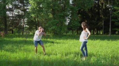 Yakışıklı adam parkta genç mutlu hamile kadın kamera ile fotoğraf çeker