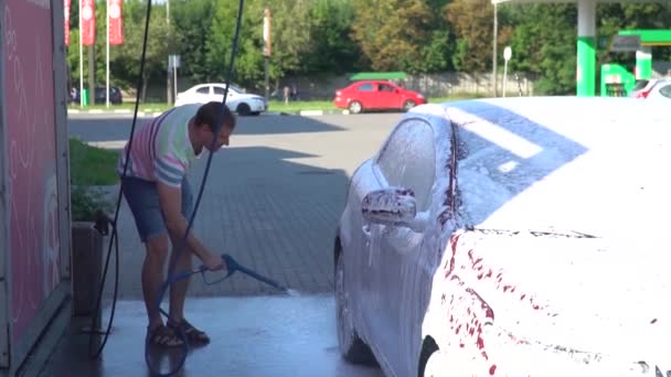Kaukázusi fiatalember mosás kocsija az autómosó önkiszolgáló. Autó mosás. — Stock videók