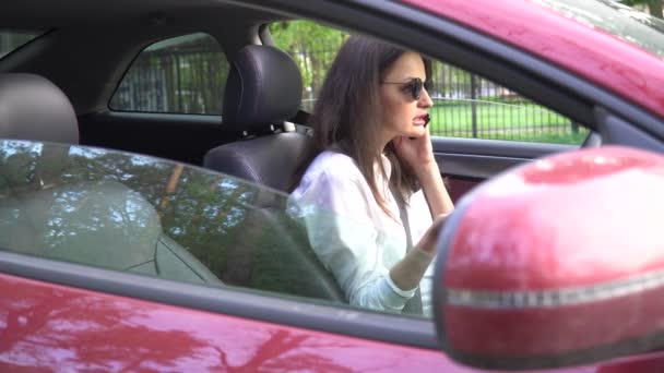 4k vrouw praten op mobiele telefoon in afgebroken auto. — Stockvideo