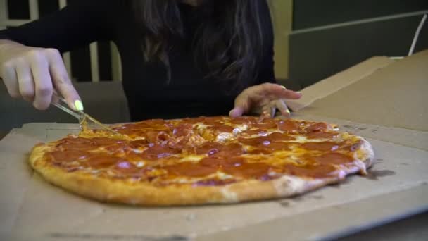 Frau schneidet in einem Restaurant eine Pizza auf. eine Frau schneidet eine Pizza. — Stockvideo